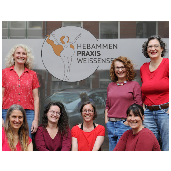 Team der Hebammenpraxis Weissensee vor der Praxis mit Logo